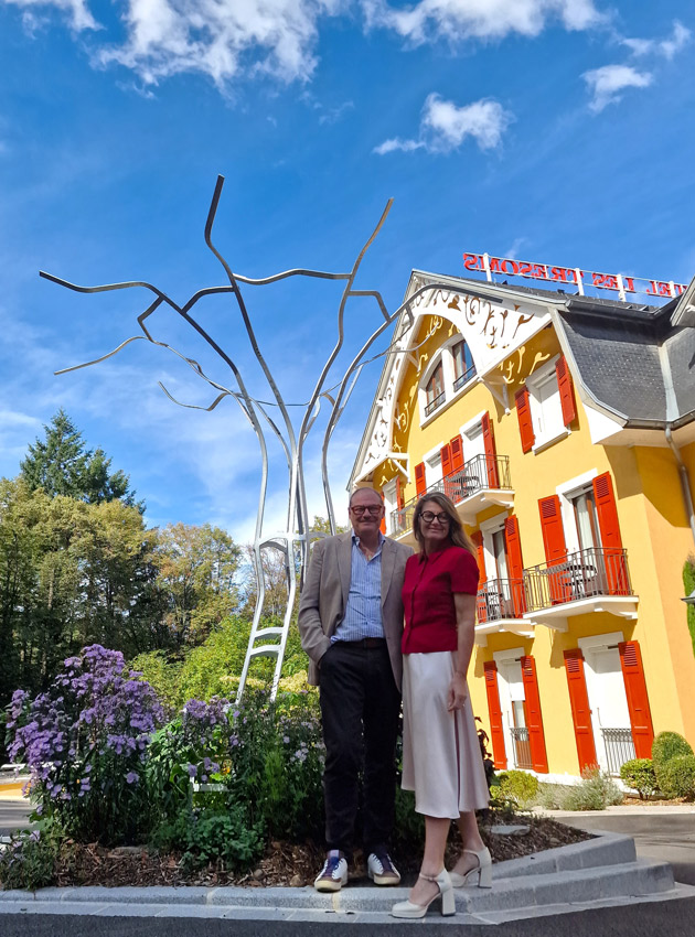 Véronique & Pascal Droux in front of the Les Trésoms and the work of art by Nathan Willerval